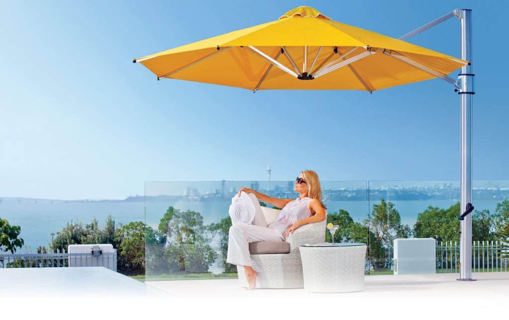 relaxing woman under yellow cantilever umbrella